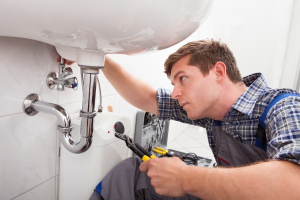 Plumber beginning work on a drain that needs to be cleaned